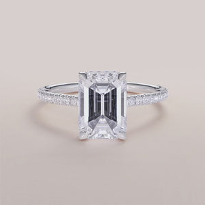 "Elegant 14K white gold engagement ring featuring an emerald with invisible gallery, hidden halo, and pave band design.