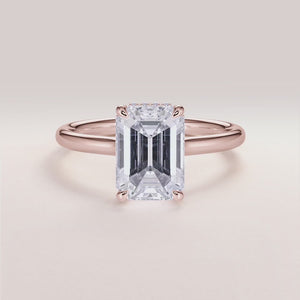 "Rose gold 14K engagement ring featuring an emerald, invisible gallery, hidden halo, and plain band design. Perfect for unique proposals.