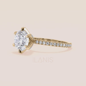 Close-up video of yellow gold round diamond engagement ring with pavé band, capturing brilliance, light reflection and accent diamond prongs in motion 
