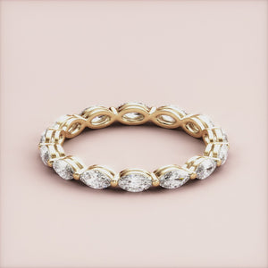 Elegant 14K yellow gold eternity band with marquise-cut diamonds, featuring an alternating infinity design, perfect for weddings. 