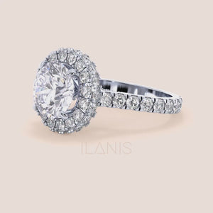 Elegant white gold engagement ring with a brilliant round-cut diamond center, encircled by a dazzling halo of smaller diamonds, adding opulence and sparkle. 