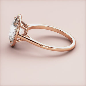 Elegant rose gold engagement ring with halo setting, featuring pear-shaped diamond, available in 14K, 18K, or platinum.