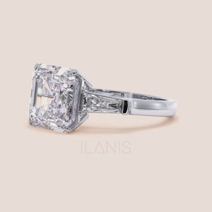 Elegant white gold engagement ring featuring a radiant cut center diamond with two side baguettes on a smooth band 
