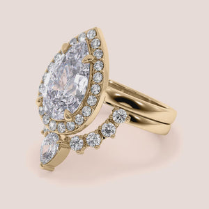 "14K yellow gold Amaya set pear halo solitaire engagement ring with cathedral band, elegant and timeless design for special occasions.