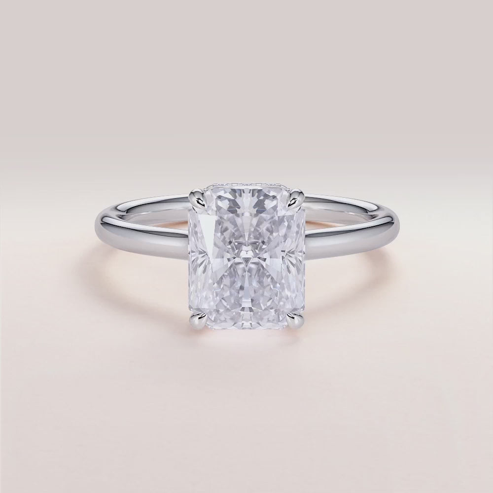 Elegant 14K white gold Jupiter radiant engagement ring featuring an invisible gallery, hidden halo, and plain band design.

#14KRecycledWhiteGold
#18KRecycledWhiteGold



#Platinum
