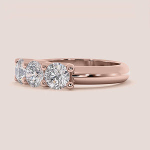 Rose gold wedding band featuring three stunning stones, available in 14K, 18K, and platinum for an elegant and timeless design. 
