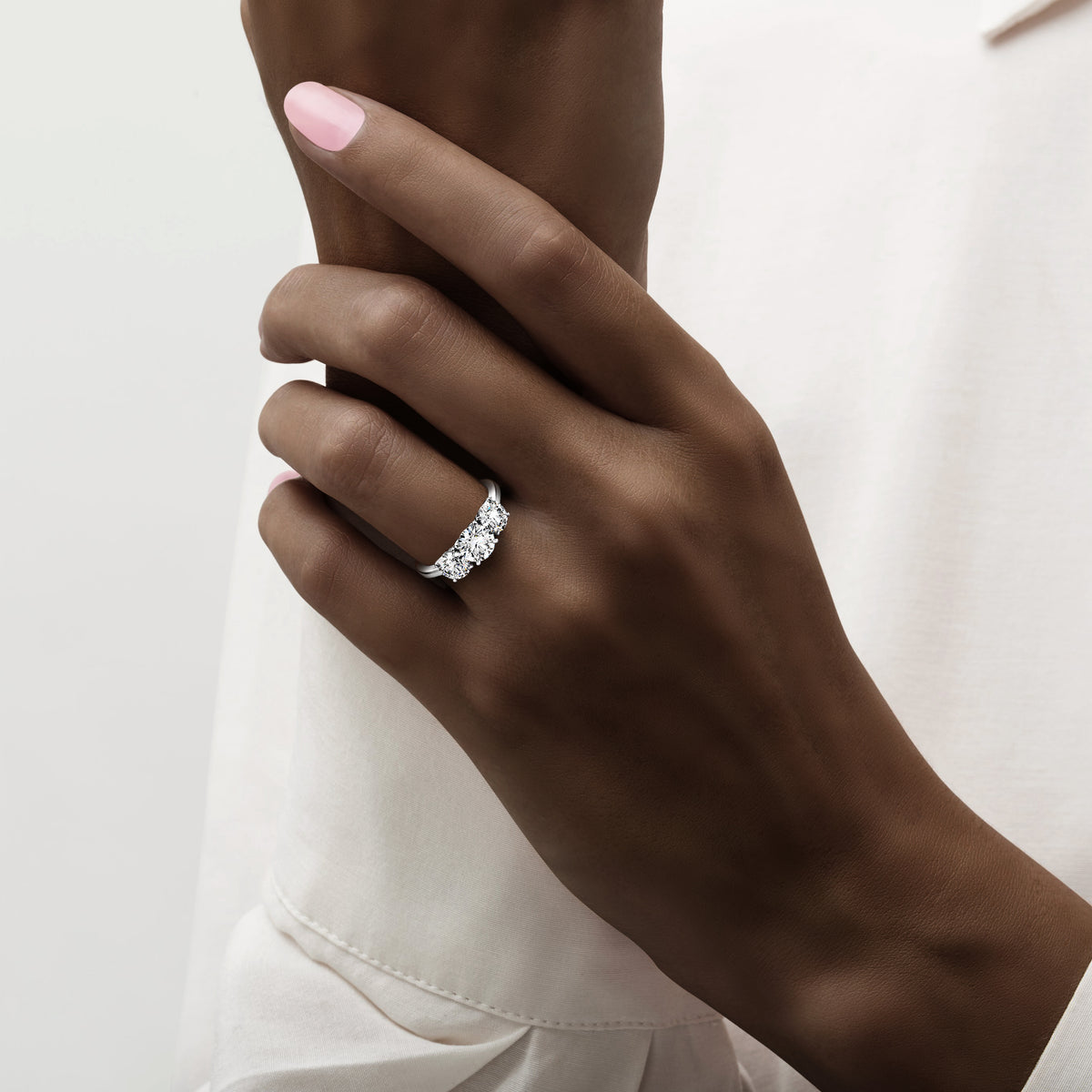 Close-up of a model wearing a stunning 14K white gold engagement ring featuring a brilliant round-cut diamond. Wedding band elegance.