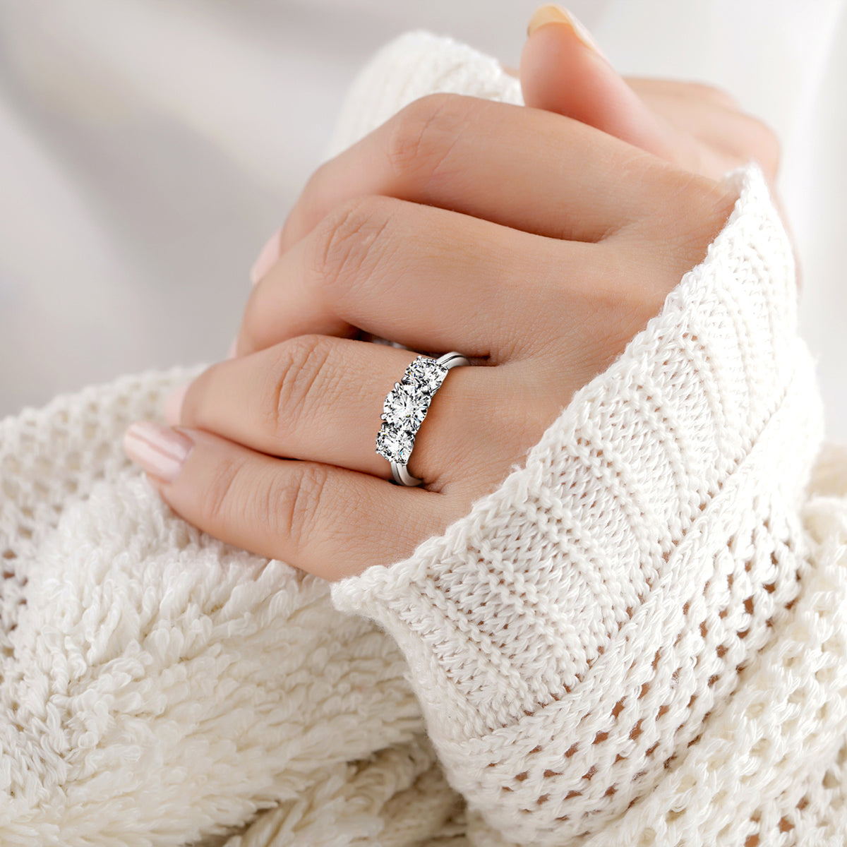 Elegant 14K or 18K white gold engagement ring with round diamond, showcased on a model against a lacy backdrop, ideal for weddings.