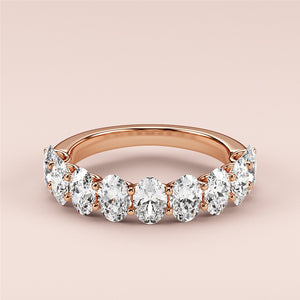 Elegant 14K or 18K rose gold wedding band featuring round brilliant-cut diamonds in a shared prong setting. 