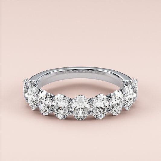 Elegant 14K, 18K, or platinum oval half eternity wedding band featuring pear-shaped diamonds against a neutral background. 