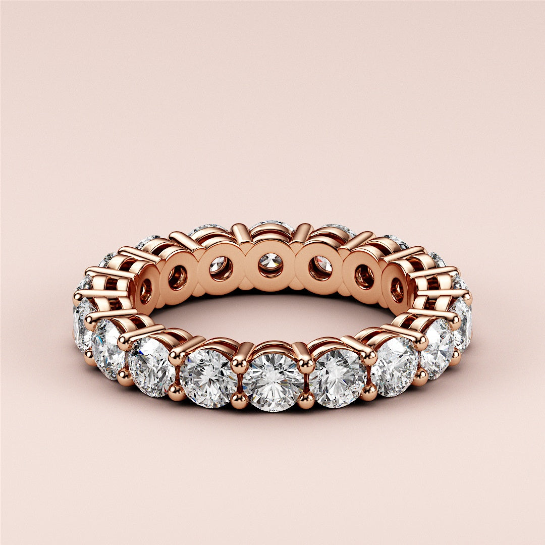 Elegant 14K or 18K rose gold eternity band with round cut diamonds in prong setting, perfect for weddings and timeless elegance. 