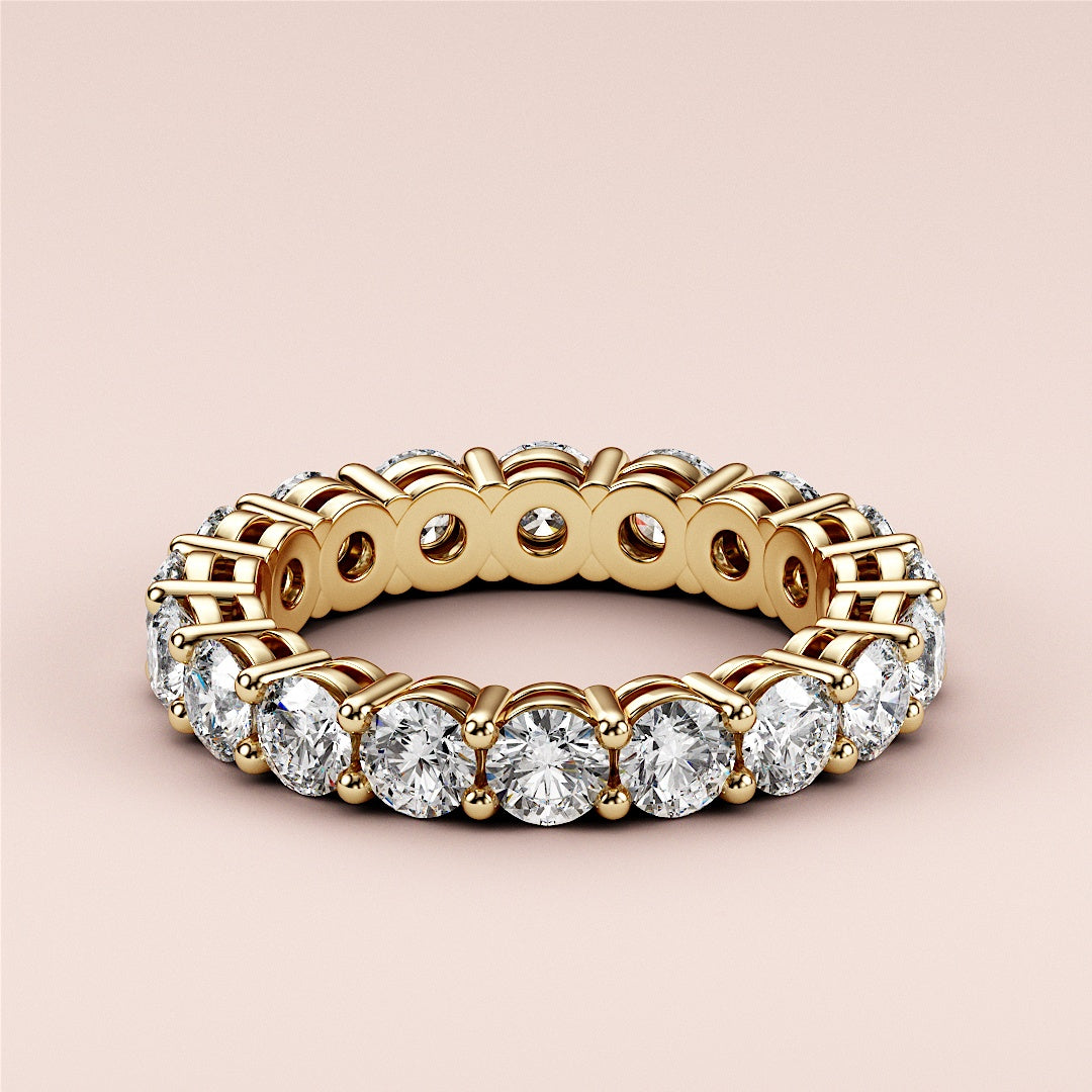 Elegant yellow gold round eternity wedding band in 14K or 18K, featuring brilliant-cut diamonds for an everlasting symbol of love. 