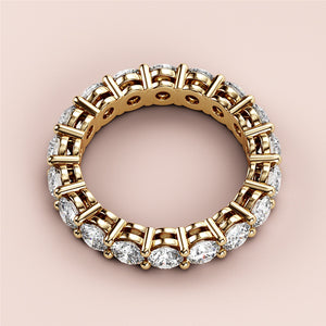 14K yellow gold eternity band ring featuring round brilliant-cut diamonds, elegantly worn on a model for a timeless wedding look. 