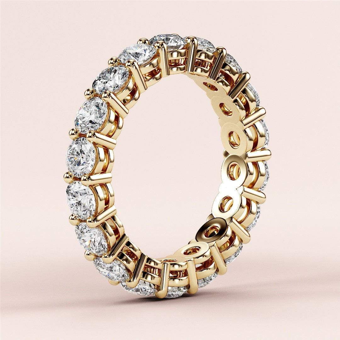 Elegant yellow gold eternity wedding band featuring round brilliant diamonds in a 360-degree prong setting, available in 14K or 18K. 
