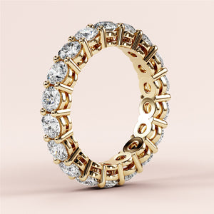 Elegant yellow gold eternity wedding band featuring round brilliant diamonds in a 360-degree prong setting, available in 14K or 18K. 