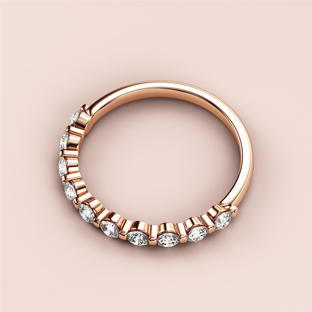 Elegant rose gold wedding band featuring round-cut diamonds in a half-eternity design, available in 14K or 18K gold and platinum. 