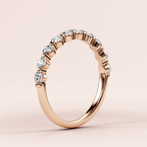 Elegant 14K rose gold half eternity wedding band with shared prong setting and dazzling round brilliant-cut diamonds. 