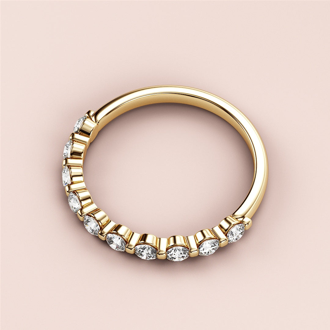 Elegant 14K Gold wedding band featuring round brilliant diamonds, showcasing half eternity shared prong design on a neutral background. 