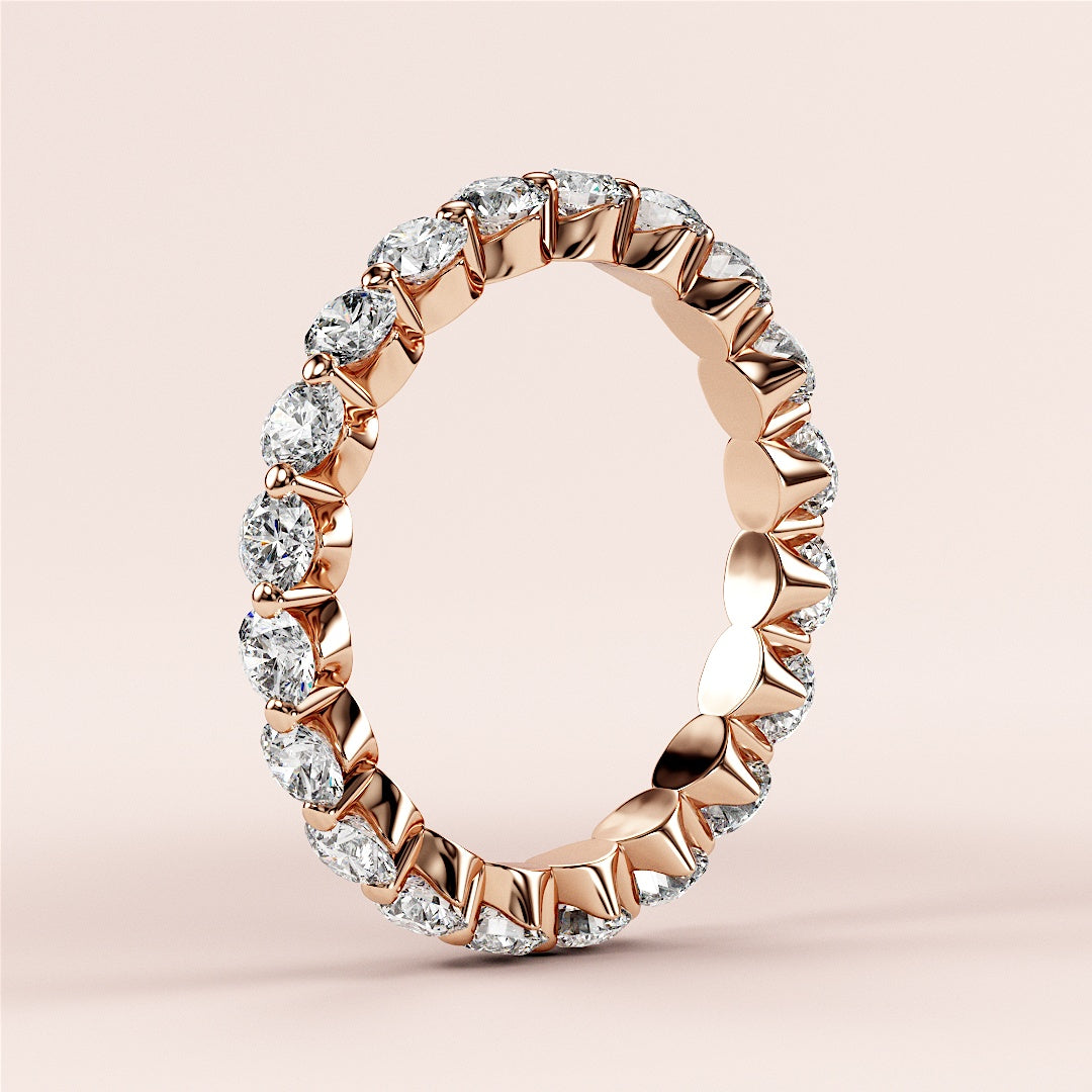 Elegant 14K Rose Gold eternity band featuring round brilliant cut diamonds in prong setting, perfect for weddings or engagements. 