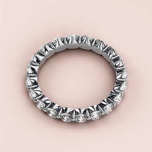 Elegant 14K white gold eternity wedding band with round brilliant-cut diamonds in shared prong setting. 