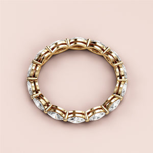 Elegant 14K yellow gold marquise-cut diamond eternity wedding band, set against a soft beige background. 