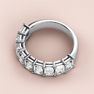 Elegant 14K/18K white gold half eternity wedding band featuring emerald-cut diamonds, close-up on soft beige background. 