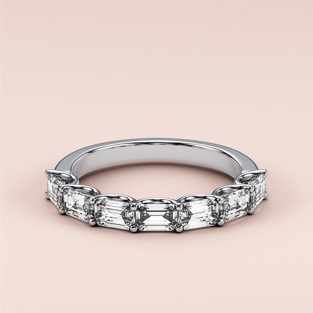 Elegant 14K or 18K white gold emerald half eternity wedding band, featuring a unique design and sparkling diamonds.  Perfect for any occasion. 