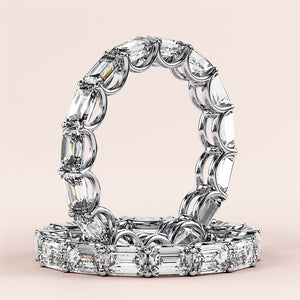 14K or 18K white gold eternity band featuring emerald-cut diamonds, elegantly displayed against a neutral background. 