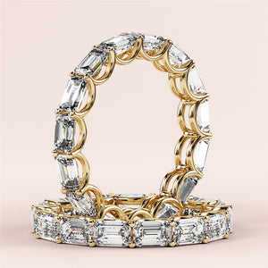 Luxurious emerald-cut diamond eternity band in 14K or 18K yellow gold, perfect for weddings and special occasions. 