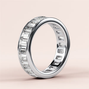 Elegant 14K or 18K white gold emerald-cut diamond eternity wedding band featuring a seamless row of elongated facets. 