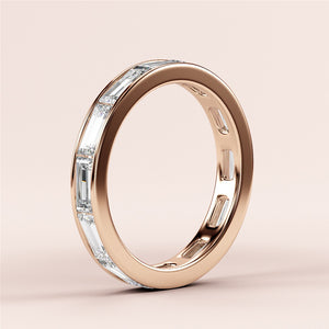 Elegant baguette-cut diamond eternity band in 14K rose gold, perfect for weddings, displayed on a soft beige background. 
