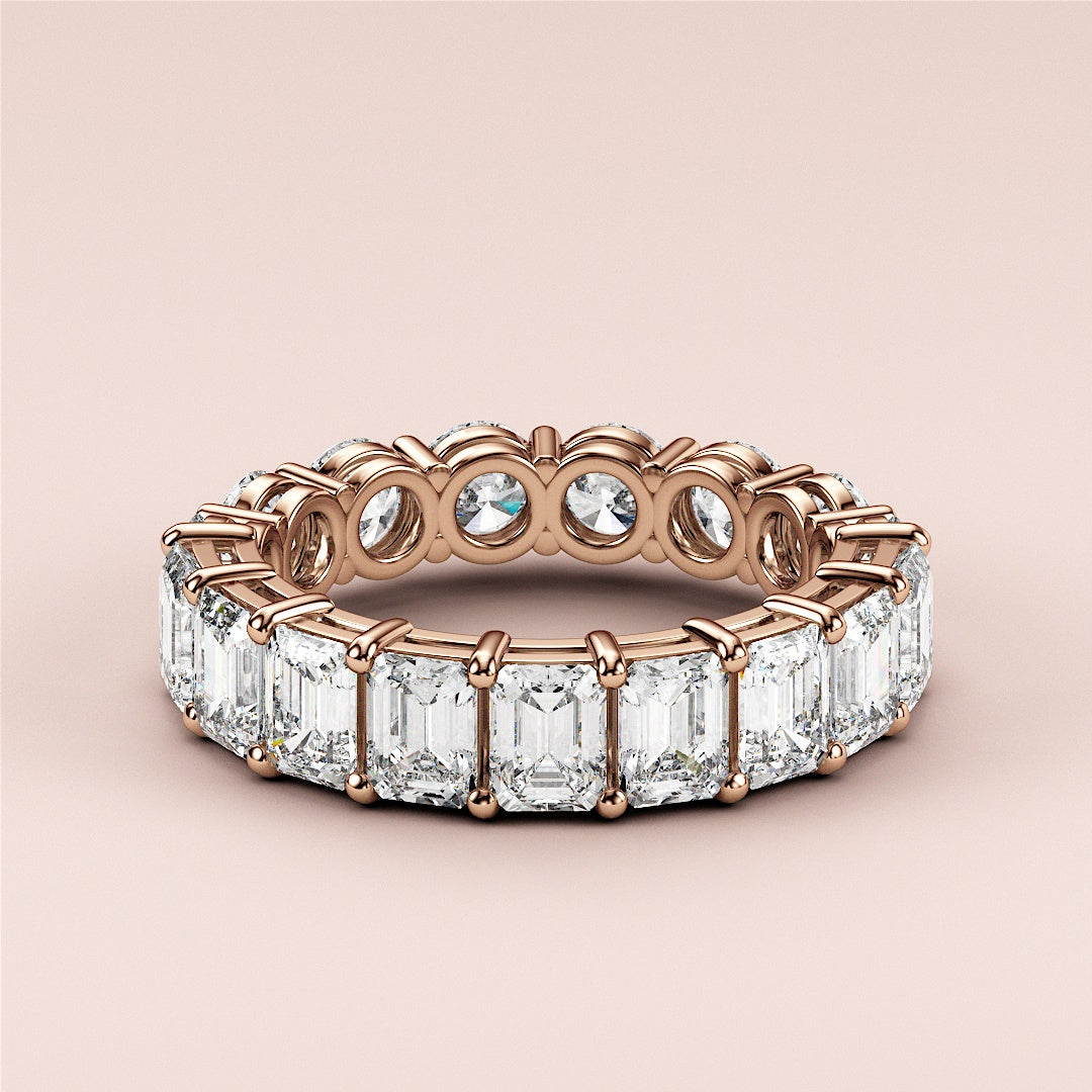 Luxurious rose gold (14K/18K) eternity band with emerald-cut diamonds, a timeless wedding band exuding elegance and sophistication. 