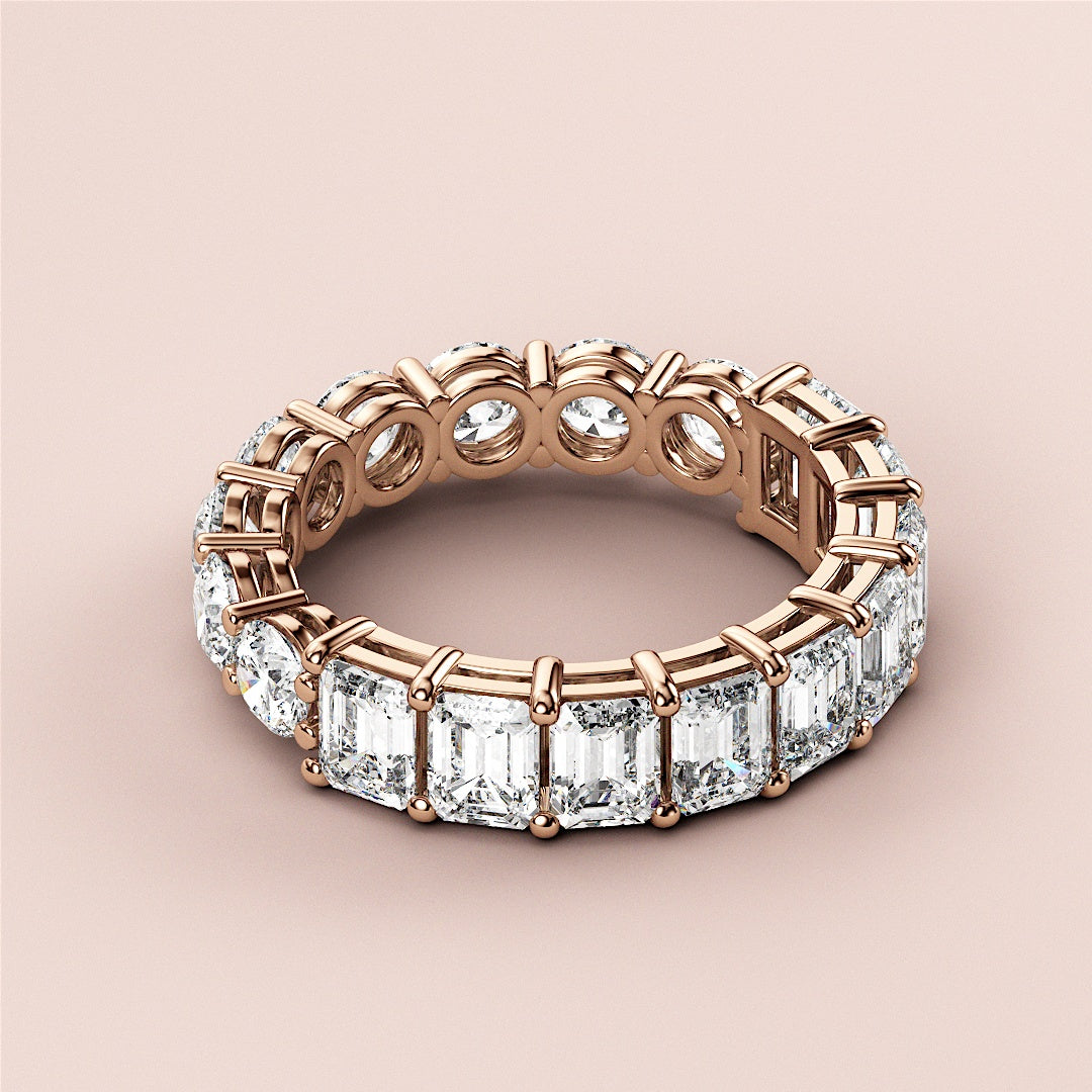 Elegant 18K rose gold half-round emerald eternity wedding band with dazzling diamonds, perfect for celebrating love. 