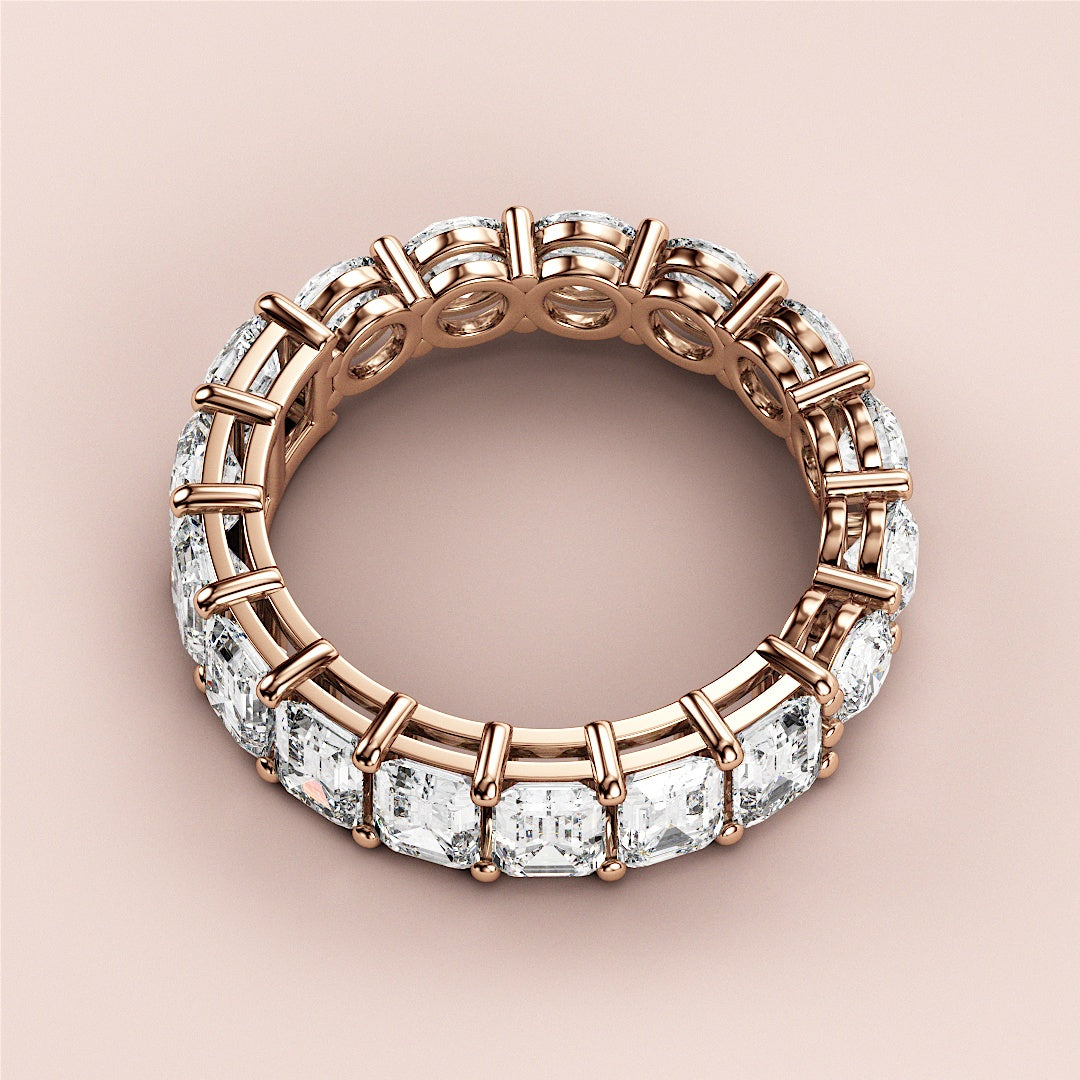 Rose gold eternity wedding band with emerald-cut diamonds, available in 14K and 18K gold or platinum. 