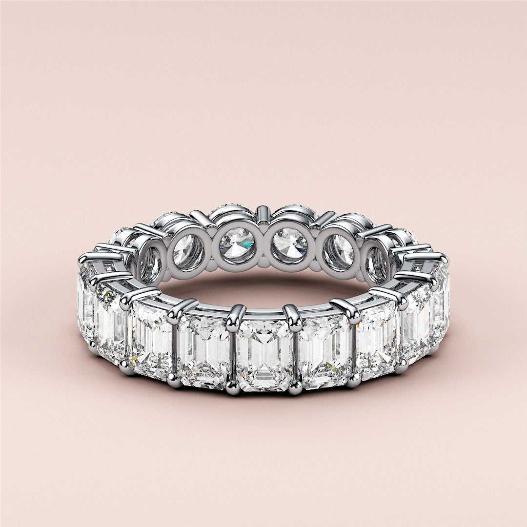 Elegant 14K white gold eternity band featuring emerald-cut and round diamonds, perfect for weddings and special occasions. 