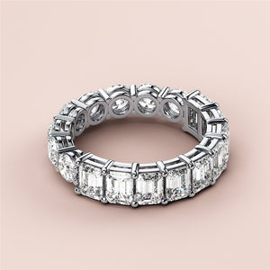 Elegant 14K or 18K white gold eternity band with radiant cut diamonds in a prong setting, perfect for weddings. 