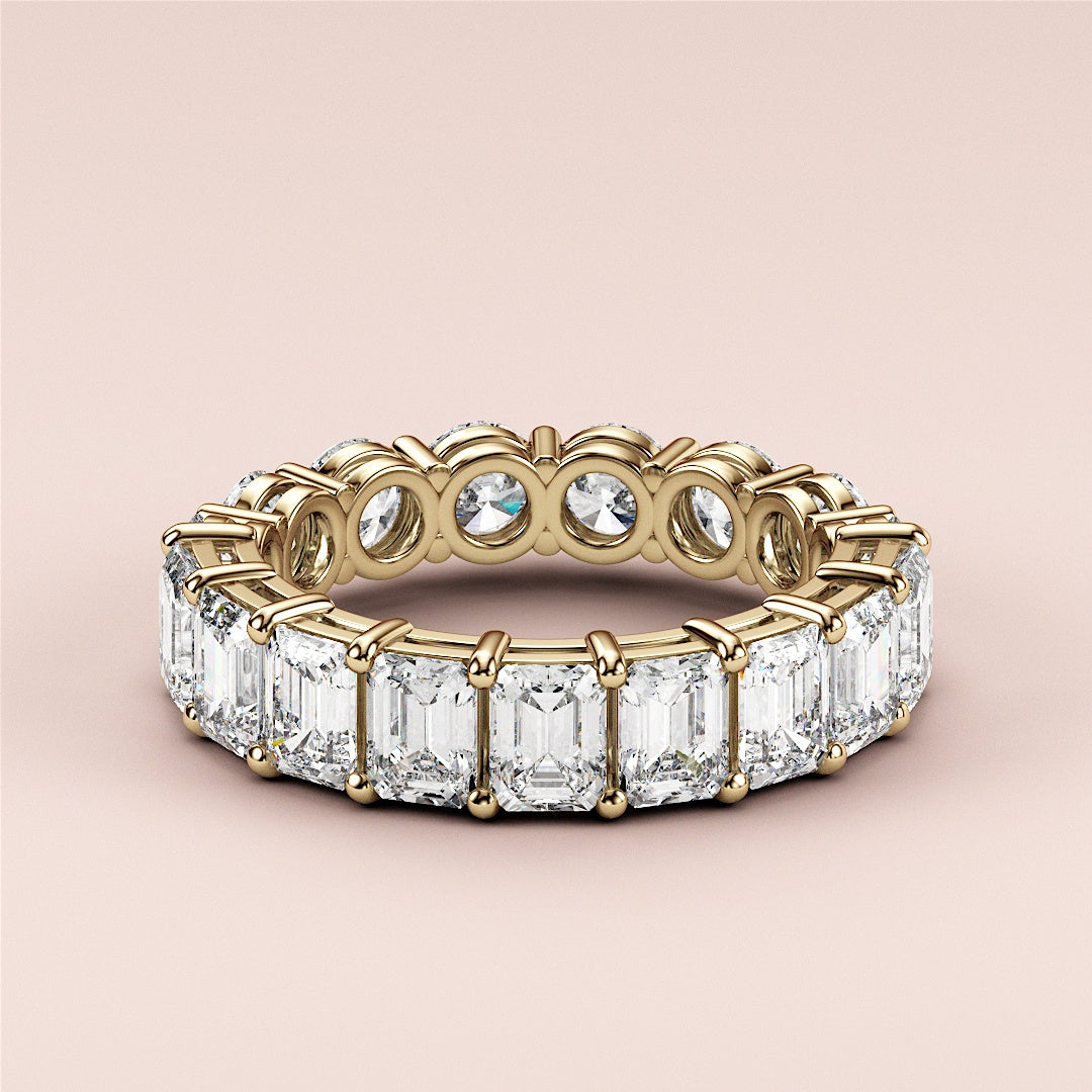 Exquisite 14K or 18K yellow gold eternity band featuring emerald-cut diamonds, perfect for weddings or special occasions. 