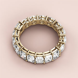 Elegant 14K yellow gold eternity band with emerald-cut diamonds in a luxurious design, perfect for weddings and special occasions. 