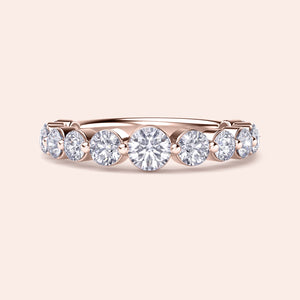 Rose Gold wedding band featuring round brilliant-cut diamonds in a shared prong setting, available in 14K or 18K gold. 