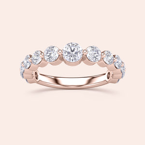 Elegant 14K or 18K rose gold wedding band featuring round brilliant cut diamonds in a shared prong setting. 