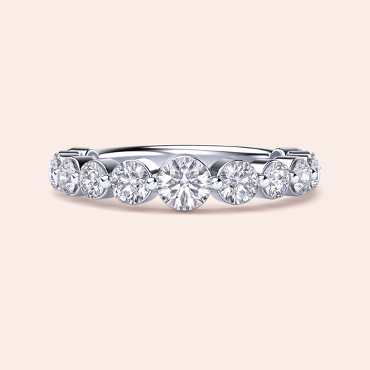 Elegant white gold wedding band featuring shared prong round brilliant cut diamonds, available in 14K or 18K options. 