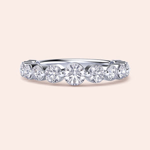 Elegant white gold wedding band featuring shared prong round brilliant cut diamonds, available in 14K or 18K options. 