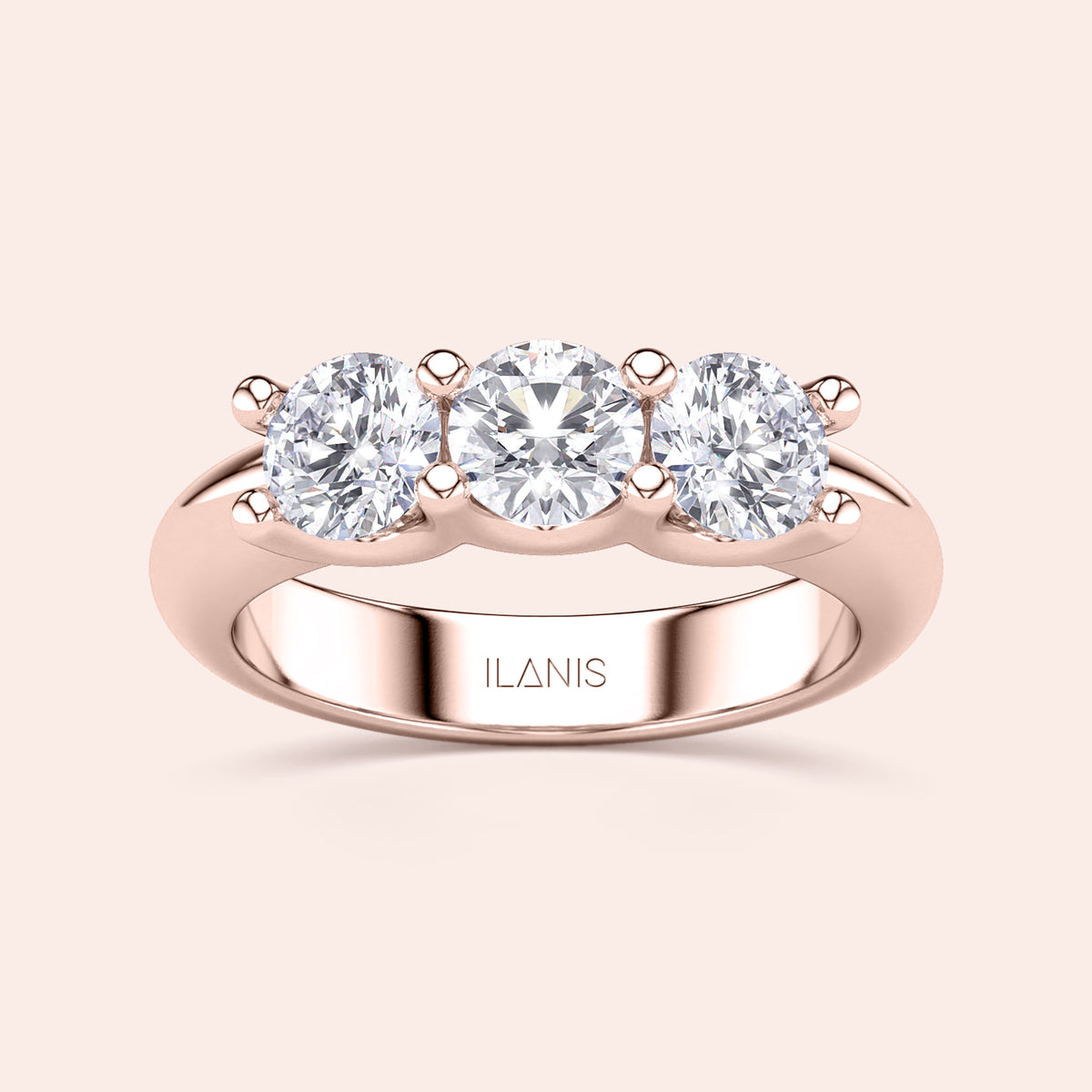 Elegant three-stone wedding band in 14K or 18K rose gold, featuring round brilliant diamonds in a prong setting. 