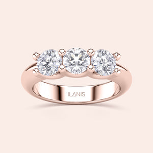 Elegant three-stone wedding band in 14K or 18K rose gold, featuring round brilliant diamonds in a prong setting. 