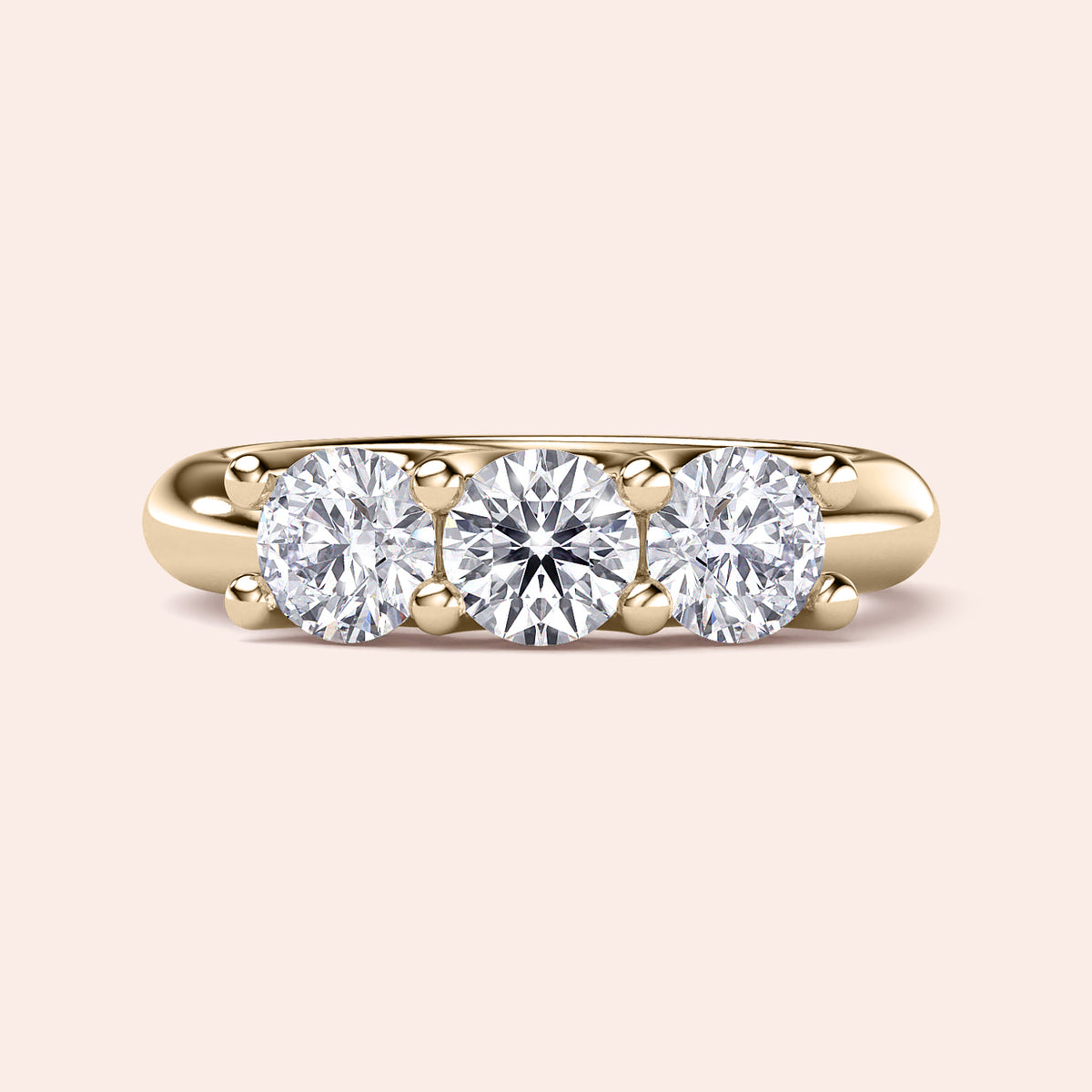 Three-stone engagement ring featuring round diamonds in a yellow gold band, available in 14K, 18K, or platinum wedding band styles. 