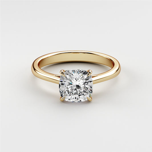 Elegant cushion-cut diamond solitaire engagement ring in 14K yellow gold setting, showcasing timeless beauty. Not worn on model.