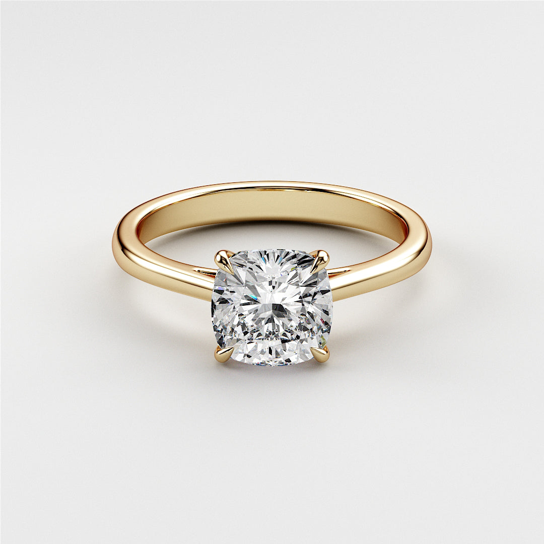 Elegant cushion-cut diamond solitaire engagement ring in 14K yellow gold setting, showcasing timeless beauty. Not worn on model.
