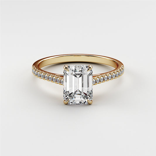 Elegant emerald-cut diamond engagement ring in a 14K yellow gold band, featuring intricate detailing and sparkling diamonds.