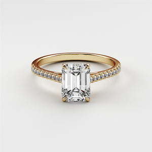 Elegant emerald-cut diamond engagement ring in a 14K yellow gold band, featuring intricate detailing and sparkling diamonds.