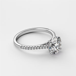 Elegant 14K white gold engagement ring featuring a round-cut diamond center stone and pave diamond band on a white background.